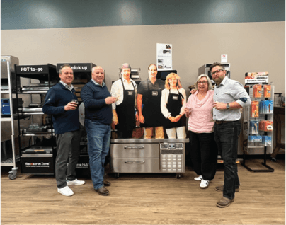 FHW team and manufacturing partners gathered around commercial kitchen equipment